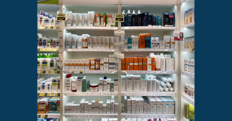 Rows of skin-care bottles, tubes and cartons with shelf labels in a drugstore